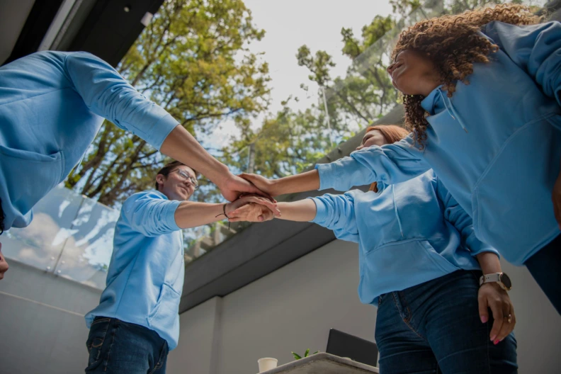 Four people joining hands